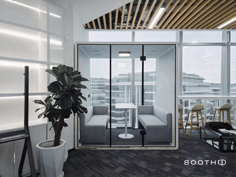 Acoustic booth with grey sofa seating beside floor-to-ceiling windows, 800TH logo visible
