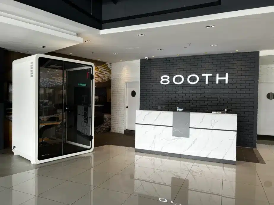 800TH showroom entrance with a black and white acoustic booth beside a marble reception desk bearing the 800TH sign on a dark brick wall