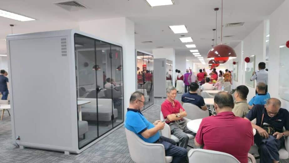 Acoustic booth in an office event space with guests seated at tables