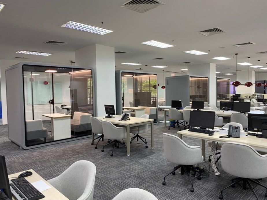 Acoustic booth built into a row of workstations in an open-plan office