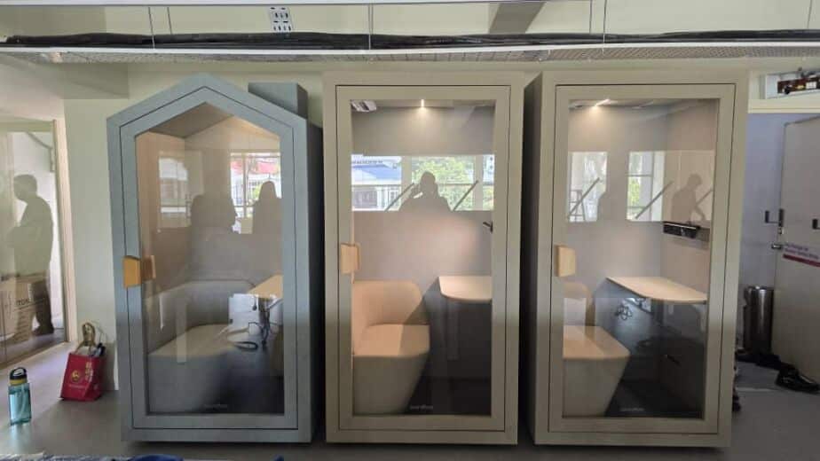 Three acoustic booths of varying sizes lined up against a window