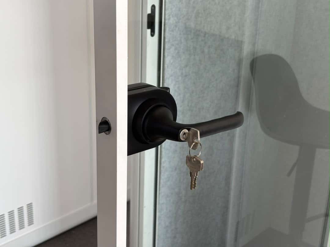 Close-up of an 8OOTH booth's door handle and key lock hardware